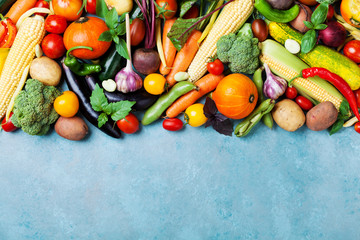 Wall Mural - Food background with autumn farm vegetables and root on blue table top view. Healthy and organic harvest.