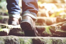 Traveler Tourist Close Up Leg Of Young Hipster Man One Person Hiker Shoe Boots Hiking. Tourist Hikers In Adventure Forest Step Trail Walking Stepping Going Up The Stairs With Sunshine. Travel Concept.