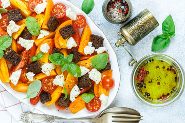 Wall Mural - Delicious summer salad of yellow and red tomatoes, croutons, cheese mozzarella,  Basil and olive oil