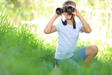 Poster - Little boy with binoculars outdoors. Summer camp