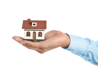 Wall Mural - Real estate agent holding house model on white background