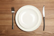 © New Africa - Empty dishware and cutlery on wooden background, top view. Table setting