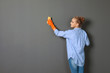 Woman in gloves cleaning grey wall with rag