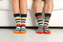 Young Couple In Matching Socks On Couch Indoors, Closeup