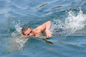  young man swims in the sea, close-up
