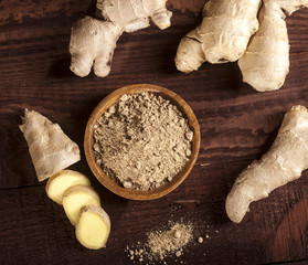 Ginger root and ginger powder on wooden background