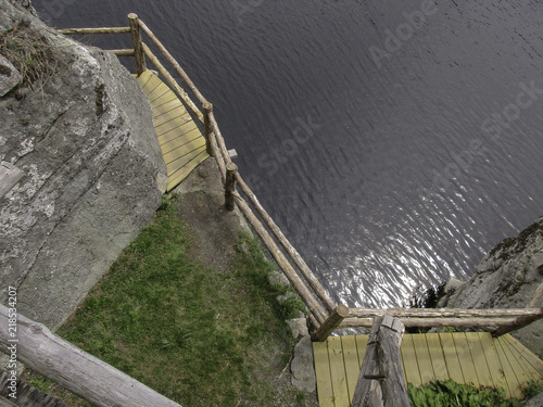 Fotografia, Obraz Rustic precarious wooden trail along a mountain lake