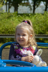 Wall Mural - the little girl shakes on a swing in the park