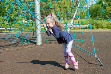 Wall Mural - the little girl climbs rope ladders in day