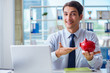 © Elnur - Businessman with piggy bank working in the office