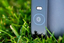 Smartphone Camera With A Flash Close-up Photo On Green Grass