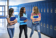 © Brocreative - Candid photo of Three Junior High school Students talking together in a school hallway. Diverse Female school girls smiling and having fun together during a break at school