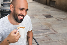 Portrait Of A Spanish Man Smiling Having Coffee Outdoors.