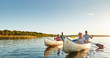 © Flamingo Images - Smiling young friends canoeing together on a lake in summer