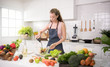 © amenic181 - Healthy young woman in a kitchen preparing vegetables for healthy meal and salad