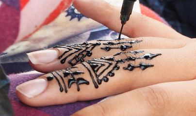 Henna tattoos being put on hands in Morocco