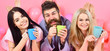 © be free - Threesome relax in morning with coffee. Lovers in bed concept. Lovers drinking coffee in bed. Man and women in domestic clothes, pajamas. Man and women, friends on happy faces lay, pink background.