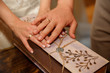 © Wedding photography - Wedding. Close-up view of young married couple, hands with wedding rings on decorated box.