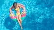 © Iuliia Sokolovska - Aerial top view of little girl in swimming pool from above, kid swims on inflatable ring donut , child has fun in blue water on family vacation resort