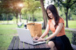 © Shutter2U - Asian woman using and typing on laptop keyboard in outdoors park. Woman chatting to her friends on social network. People and lifestyle concept. Nature and technology theme.