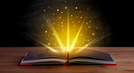 Wall Mural - Yellow lights and sparkles coming from an open book 