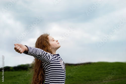 Fotomural Little girl closed her eyes and breathing with fresh blowing air.