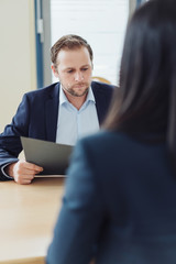 Poster - Manager liest die Bewerbungsunterlagen einer Bewerberin