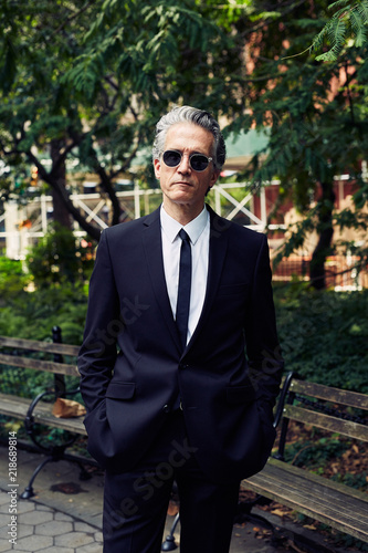 Grey Haired Caucasian Man Dressed In Contemporary Black Suit For