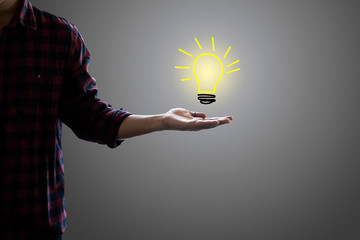 Wall Mural - drawing light bulb in hand businessman on gray background. concept for idea, innovation and inspirat