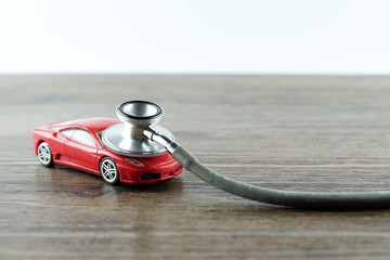 Sticker - Stethoscope checking up the car on wooden table, Concept of car check up, repair and maintenance..