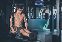 Strong Sportsman Is Doing L Sit With Gymnastic Outfit. He Is Balancing In Support Position And Raising Straight Legs To Parallel. Copy Space In Right Side