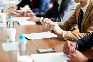 Wall Mural - One of politician sitting by table with his hands over document during political summit or conference