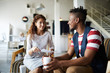 © pressmaster - Smiling African young man with disposable coffee cup attending job interview, he is communicating with young businesswoman