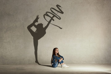 baby girl dreaming about gymnast profession. childhood and dream concept. conceptual image with shad