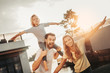 © Yakobchuk Olena - We can fly as planes. Portrait of optimistic bearded man keeping smiling girl on shoulders. She gesticulating hands with glad female. Happy parents and kid entertaining together outdoor concept