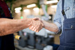 © pressmaster - Close-up of two workers shaking hands with each other at the industrial factory