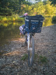 Buntes Fahrrad steht am Flussufer. Ein Damenfahrrad mit blauem Dekorationen parkt auf Kieselsteinen am Ufer der Ruhr in Deutschland.