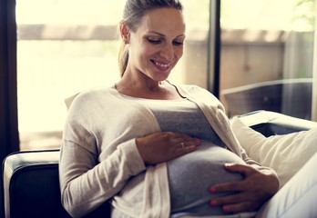 Wall Mural - A cheerful pregnant woman sitting