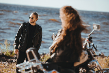 Canvas Print - selective focus of girlfriend sitting on vintage motorbike and looking at boyfriend in black leather jacket