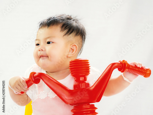 Portrait Of Cute Short Hair Asia Baby Girl Riding Red