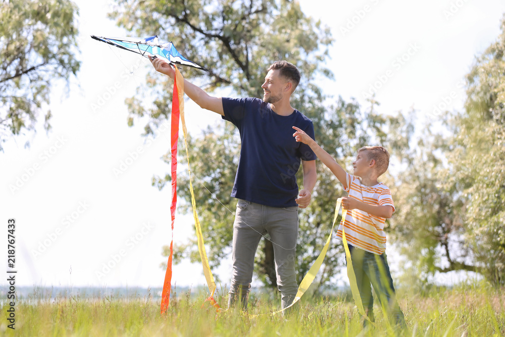 Little boy and his dad with kite outdoors