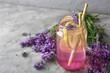 Glass jar with lavender lemonade on grey textured background