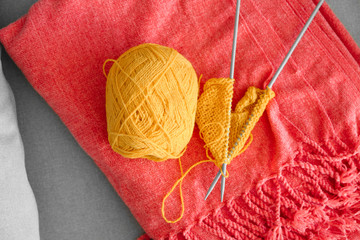 Knitting yarn with unfinished clothes on soft plaid