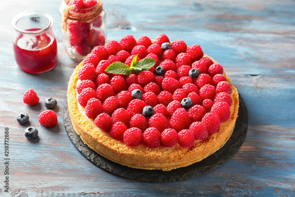 Delicious cheesecake with raspberries on wooden table