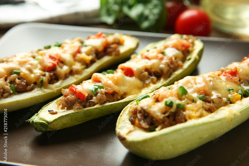 Meat stuffed zucchini boats on plate, closeup