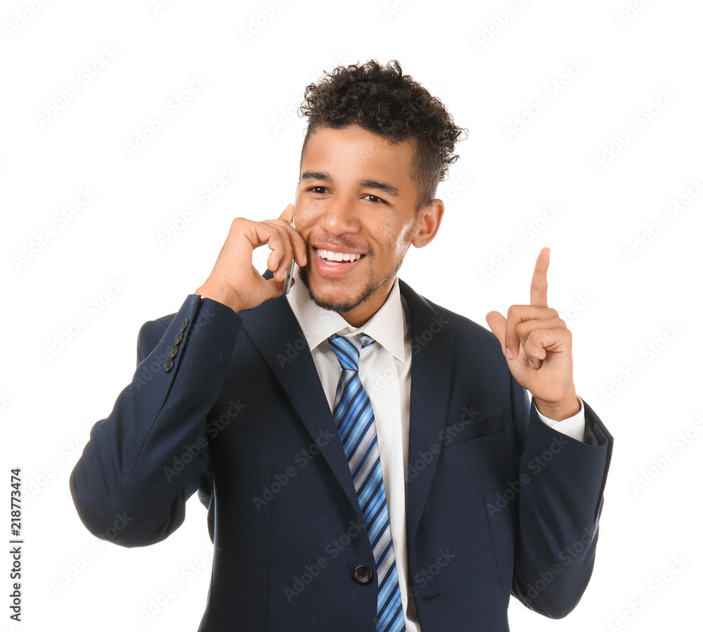 Handsome African-American businessman talking by mobile phone on white background