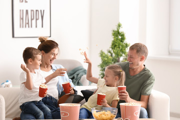 Wall Mural - Family playing with popcorn while watching TV at home