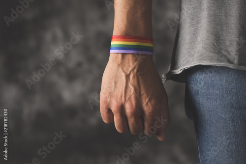 man with a rainbow-patterned ribbon in his wrist Fotobehang