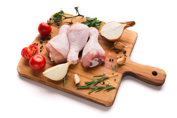 Raw chicken legs on wooden board isolated