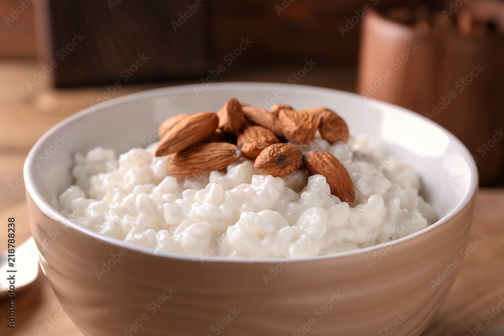 Delicious rice pudding with almonds in bowl, closeup